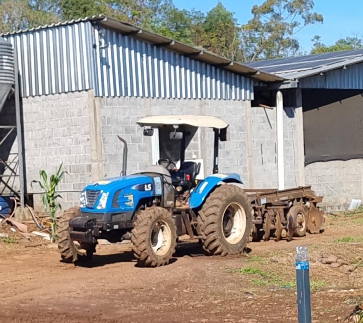 Trator LS Plus 90 ROPS 4x4 da Associação, acoplado à grade aradora